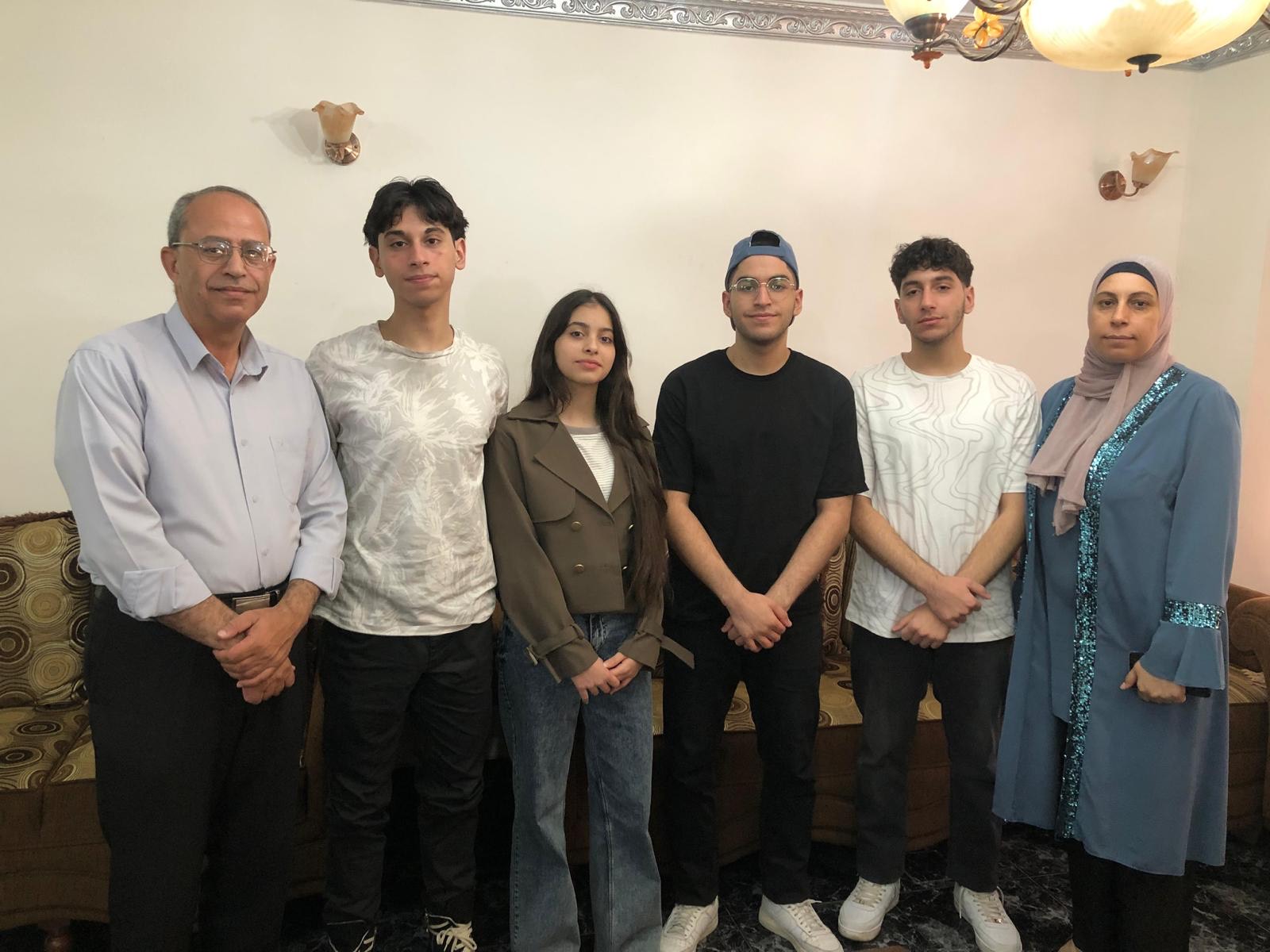 التوائم هلا وهادي وقيس ويوسف مع والديهم. (تصوير أحمد مزهر/وفا) 